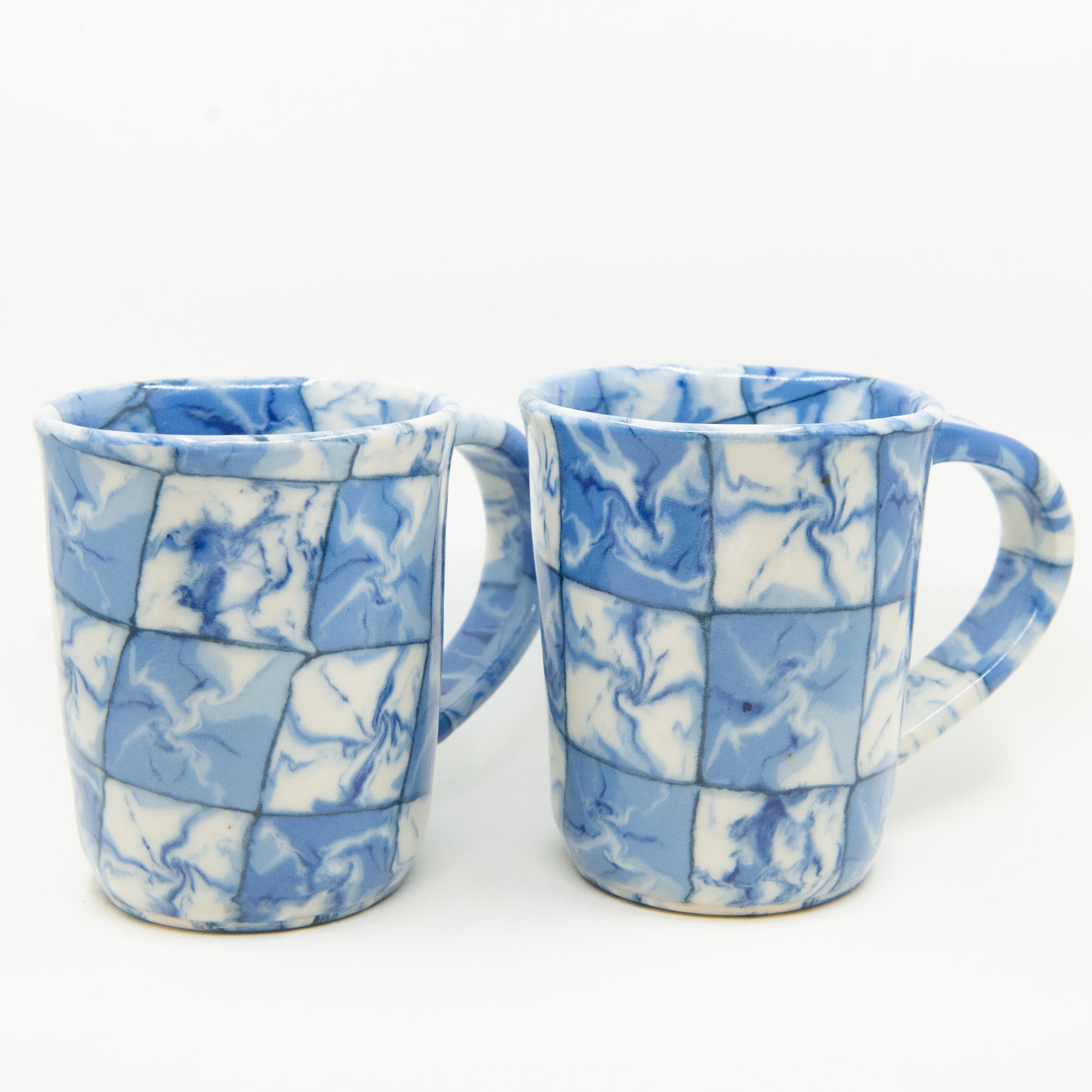 Handmade blue and white patterned mugs.