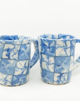 Handmade blue and white patterned mugs.