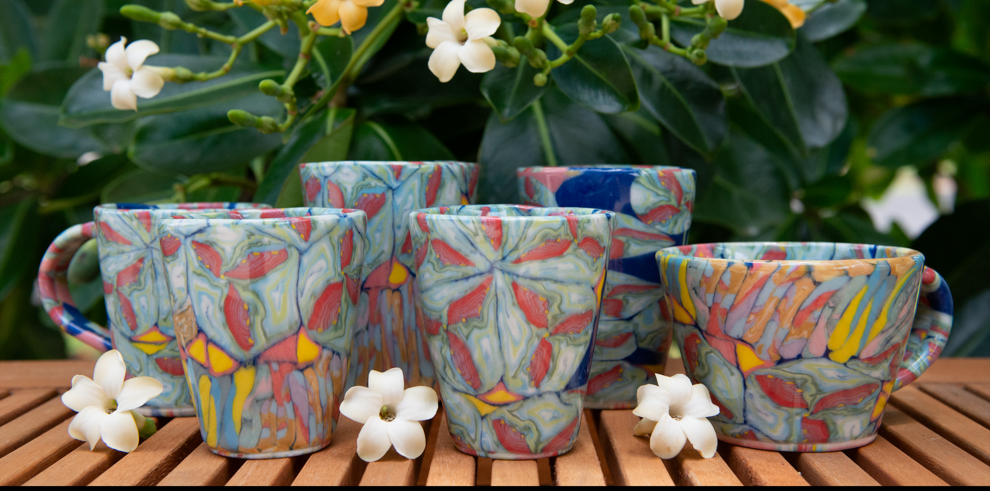 Collection of colorful handmade cups with flowers.